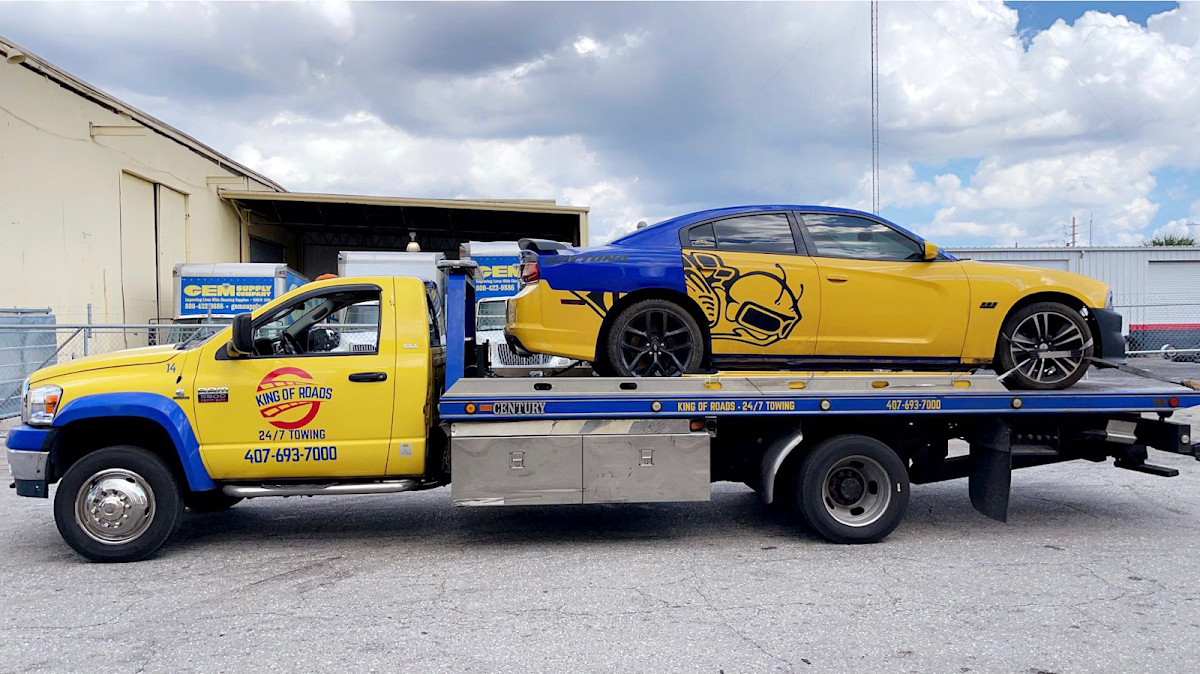 Yellow Tow Me Orlando truck hauling a car