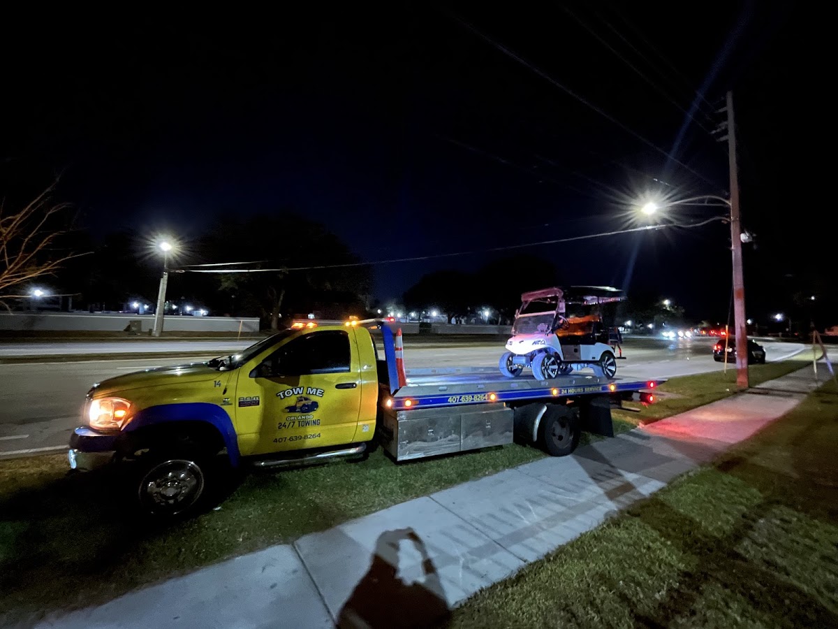 Tow Me Orlando yellow truck working at night under streetlights